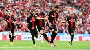 The Bayer Leverkusen players celebrate a goal.